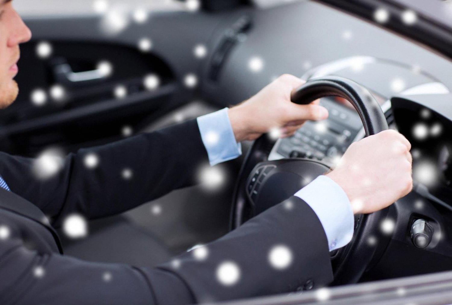 Chauffeur in a dark suit driving a client through Dubai traffic