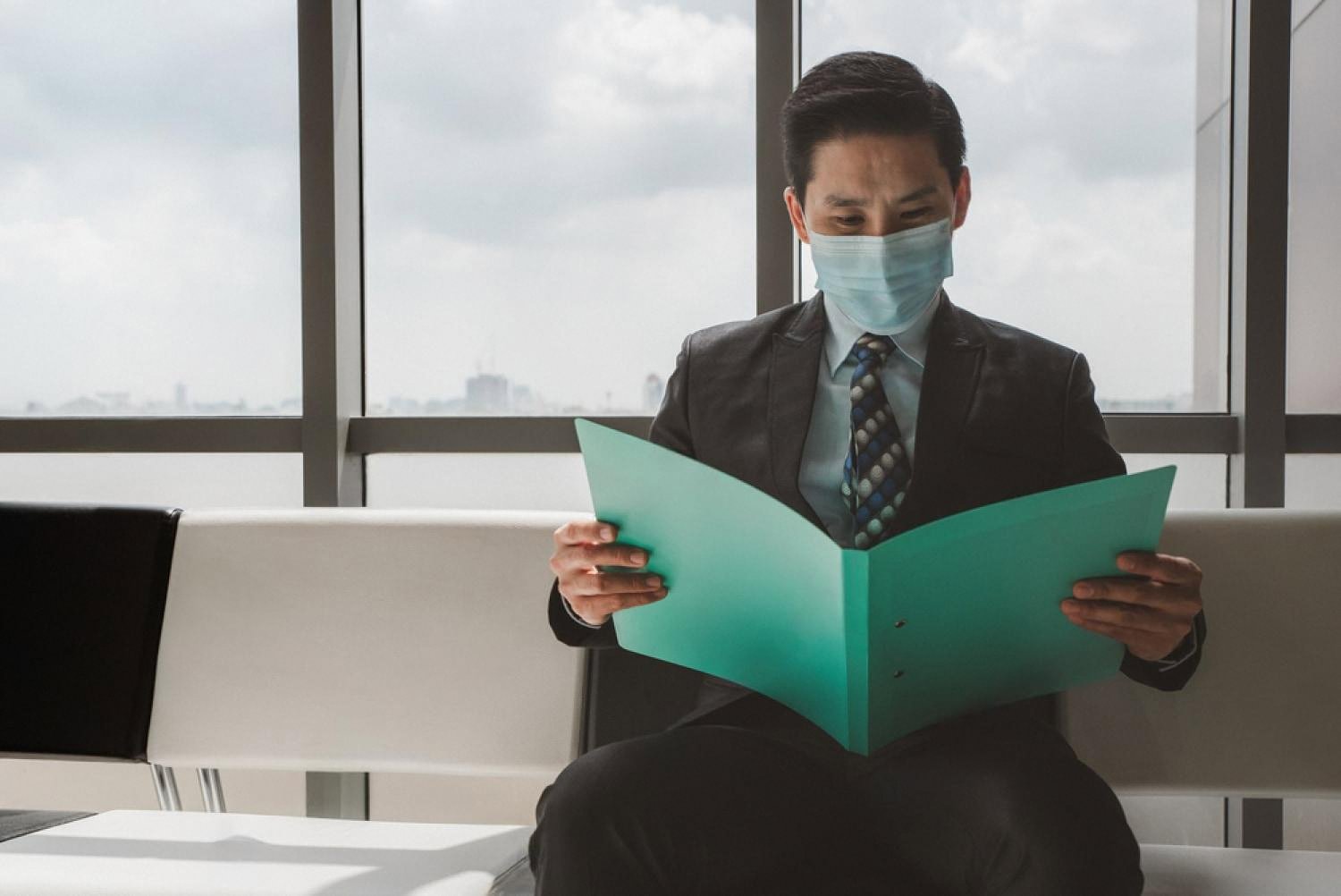 Corporate officer reading a confidential document folder in a Dubai office