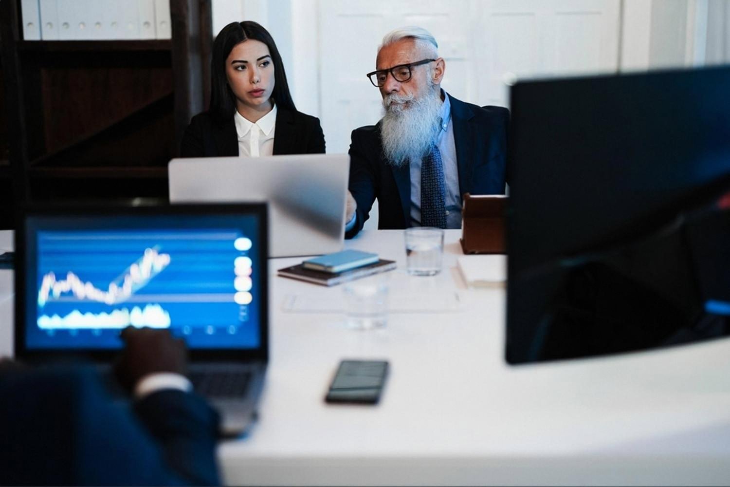 Two UAE executives reviewing sensitive company data on a laptop in a boardroom
